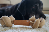 HuggleGroup Huggle-Hide Natural Leather Knotted Bone dog chew toy shown from side angle highlighting textured surface.