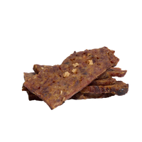 Saint Rocco's Treats Pork and Apple jerky strips being enjoyed by a dog or shown in lifestyle setting.