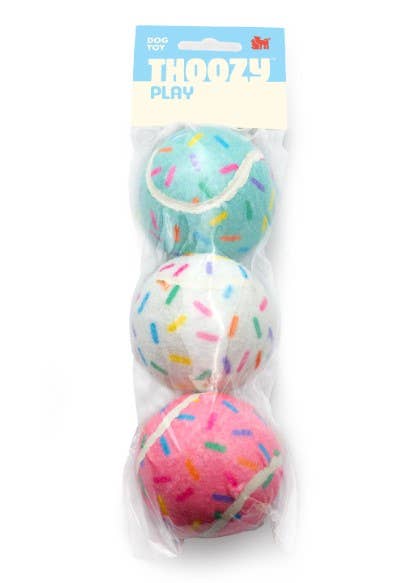 Three Pet Palette Distribution Birthday Sprinkle Tennis Balls with colorful sprinkle pattern on fuzzy yellow surface.