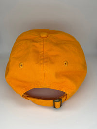 BARK JAX orange cotton hat with cream embroidered Dog Vibes Only text worn in casual lifestyle setting