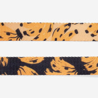 Close-up detail of Zee.Dog H Harness in Bossa Banana yellow pattern showing hardware and strap construction.