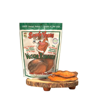 Sam's Yams Veggie Rawhide packaging with dog treats on a wooden stand outdoors.
