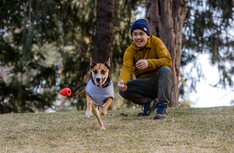 Ruffwear Gnawt-A-Cone natural latex rubber dog toy being chewed by a dog outdoors