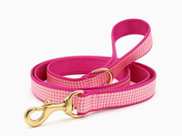 Pink gingham dog leash with gold clasp on a white background