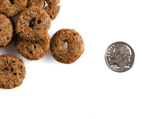 Fromm Crunchy O's Blueberry Blasts dog treats scattered on a surface showing their round, crunchy texture.