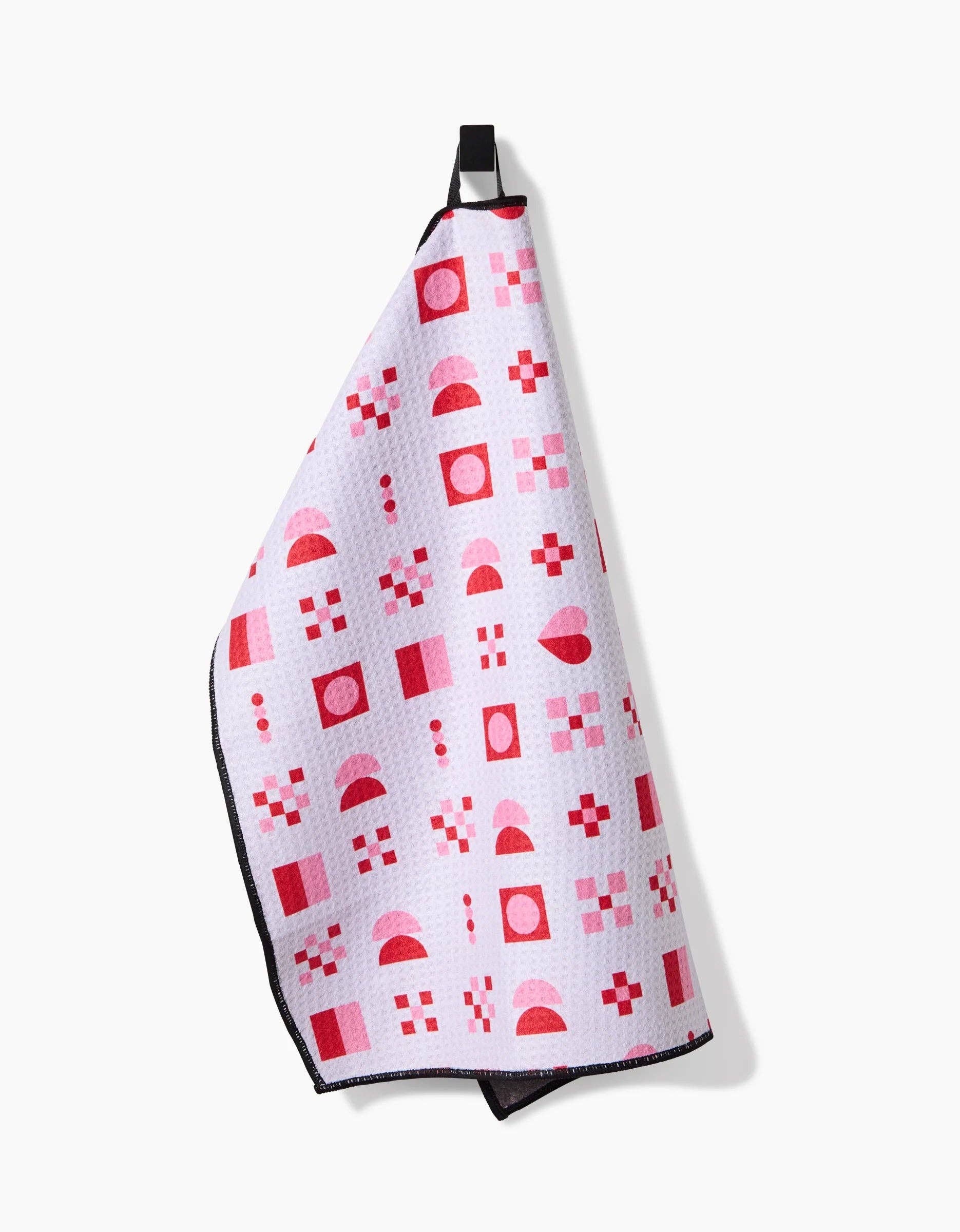 Geometry Heart Quilt Paw Towel being used to dry a dog's paws after outdoor activity.