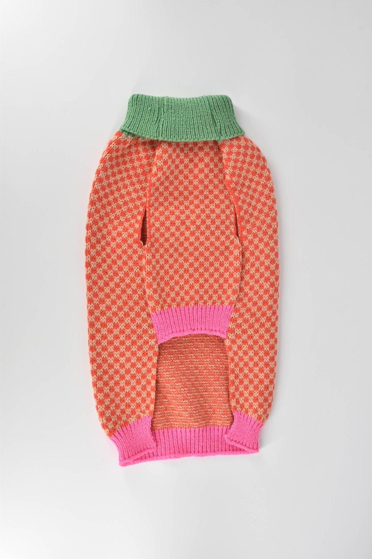 A dog wearing the Finnegan's Standard Goods Gingersnap Checker Sweater shown from a side angle outdoors.