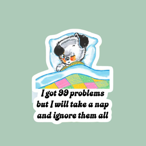 Cartoon cat in bed with colorful checkered background and text 'I got 99 problems but I will take a nap and ignore them all'.