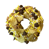 Dog Dish Chunky Monkey Granola Donut topped with banana chips, carob drops, peanut butter chips, and yellow sprinkles.