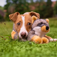 Dog Dish Fluff & Tuff Sterling Fox plush toy being cuddled by a brown and white dog on green grass