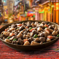 Dog Dish Fromm beef stew with chunks of meat, potatoes, carrots, and peas in a savory broth served in a bowl.