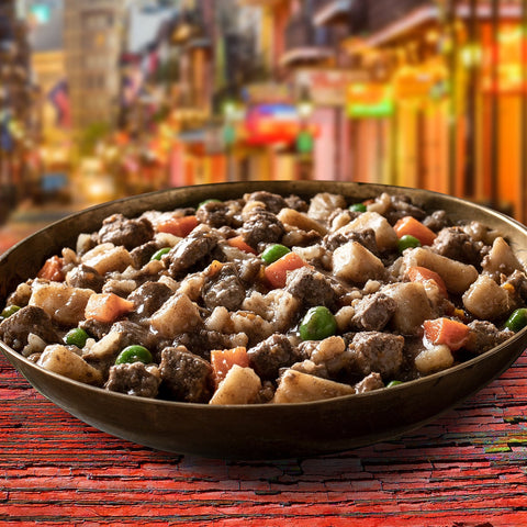 Dog Dish Fromm beef stew with chunks of meat, potatoes, carrots, and peas in a savory broth served in a bowl.