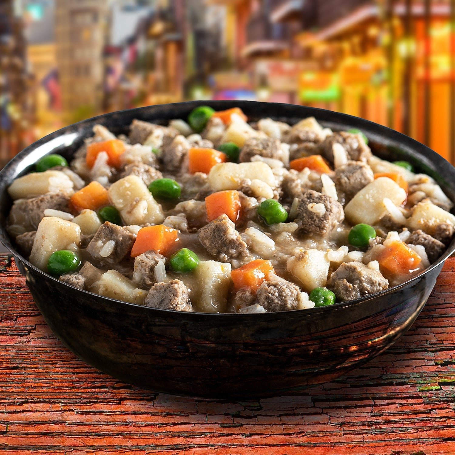 Dog Dish Fromm Family Frommbalaya chicken, vegetable, and rice stew in a bowl on a rustic wooden table.