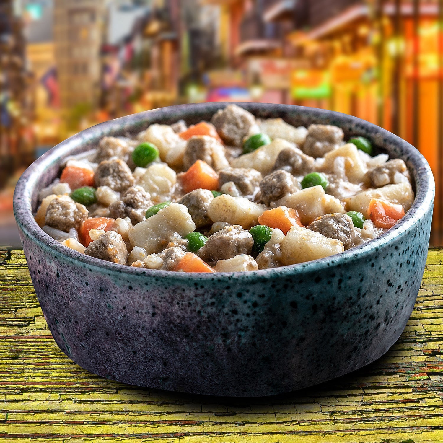 Dog Dish Fromm turkey stew with chunks of meat, potatoes, carrots, and peas in a speckled bowl on a rustic table.