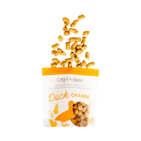 Dog Dish Green Juju freeze-dried duck and orange dog treats falling into a clear pouch with orange branding