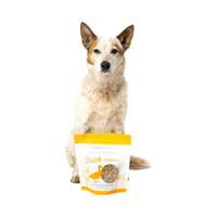 Dog Dish Green Juju Duck Orange freeze-dried dog treats in a pouch with a sitting Australian Cattle Dog