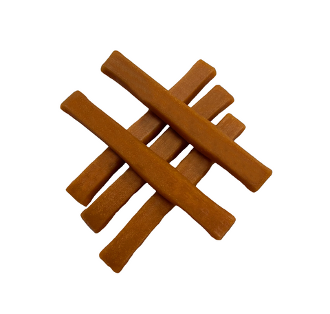 Close-up detail of Himalayan Dog Chew Yogurt Sticks in Pumpkin flavor showing treat texture and shape.