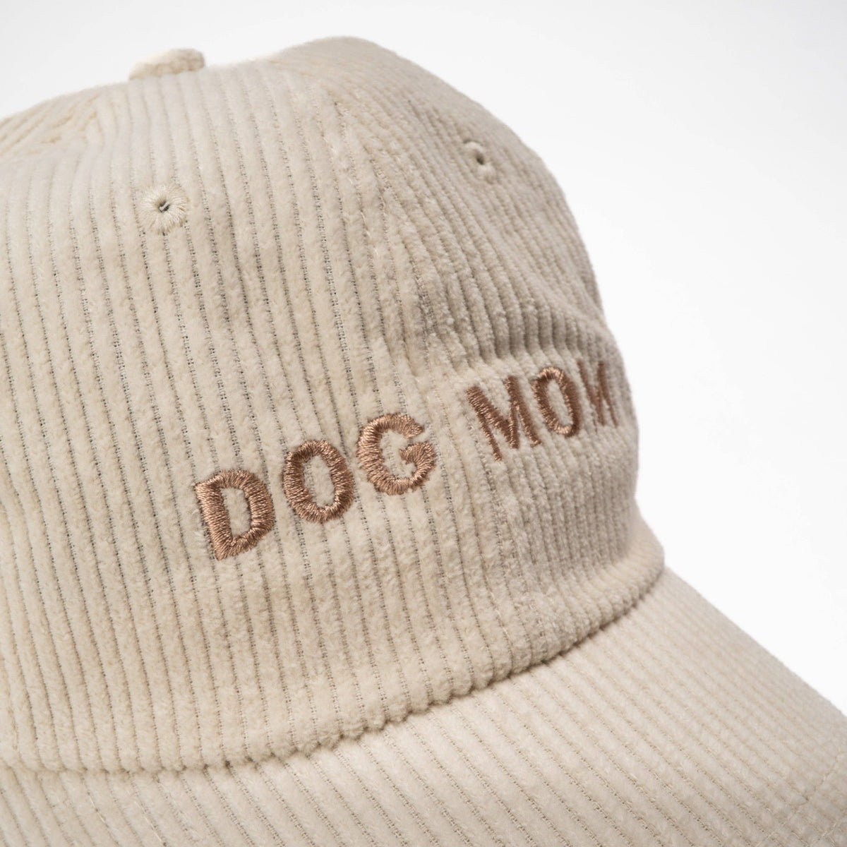 Dog Dish ivory corduroy baseball cap with Dog Mom embroidered in brown thread, featuring a soft textured finish.