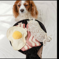 Dog Dish Lambwolf breakfast enrichment toy set with plush egg, bacon, and sausage in a black pan for dogs