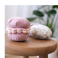 Dog Dish Lambwolf Cookie Enrichment Set featuring a pink macaroon and textured madeleine dog puzzle toys on a stool.