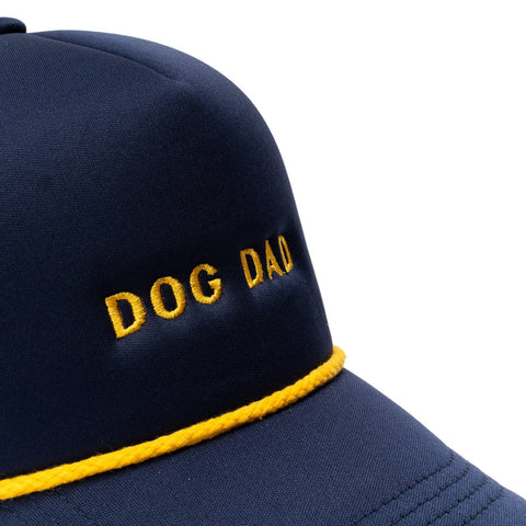 Dog Dish navy trucker hat with yellow Dog Dad embroidery and matching yellow rope detail on the brim