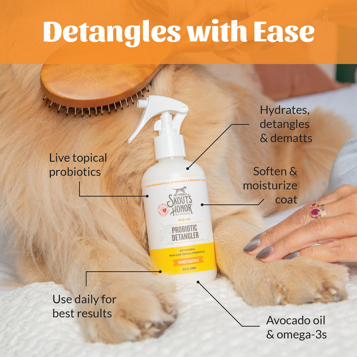 Dog Dish Skout's Honor probiotic honeysuckle detangler spray bottle being used on a golden dog's coat with a brush.